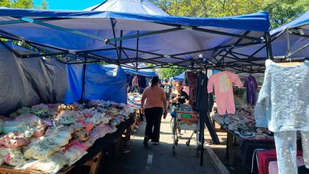 Pasillo de puestos de ropa usada y calzado deportivo