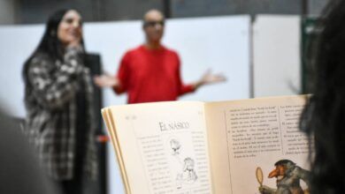 Imagen de una persona leyendo un libro en una biblioteca